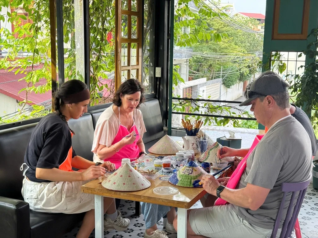 Khách nước ngoài trải nghiệm vẽ nón lá
